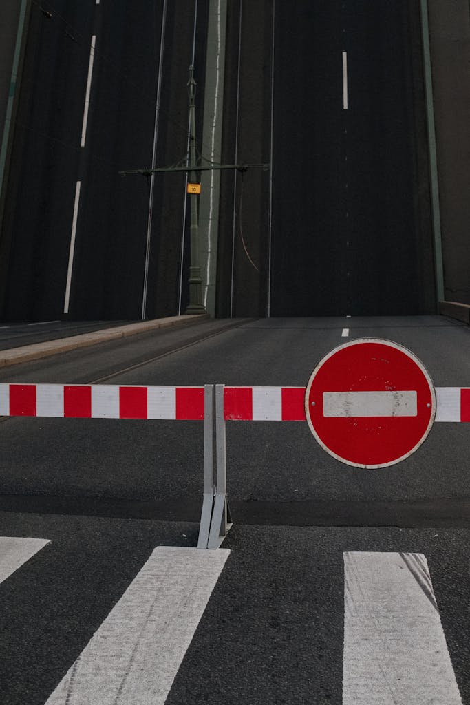 An empty city street with a closed drawbridge and a no-entry sign.
